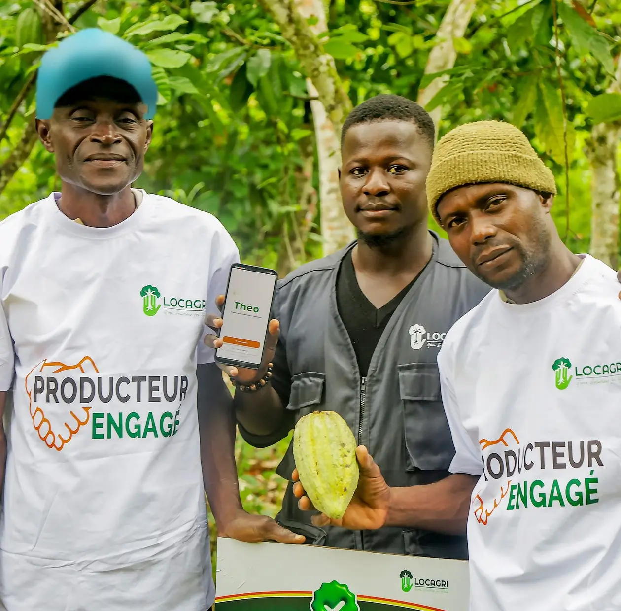 Participating farmers and a LOCAGRI technician, holding a cocoa pod and a phone